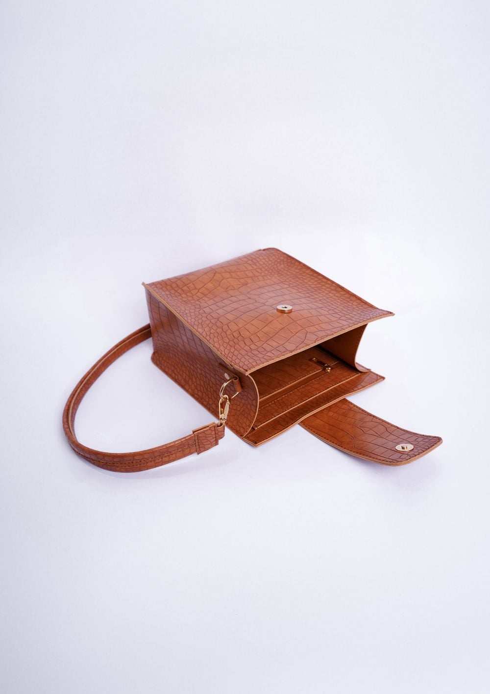 Brown textured leather bag with its strap and interior visible
