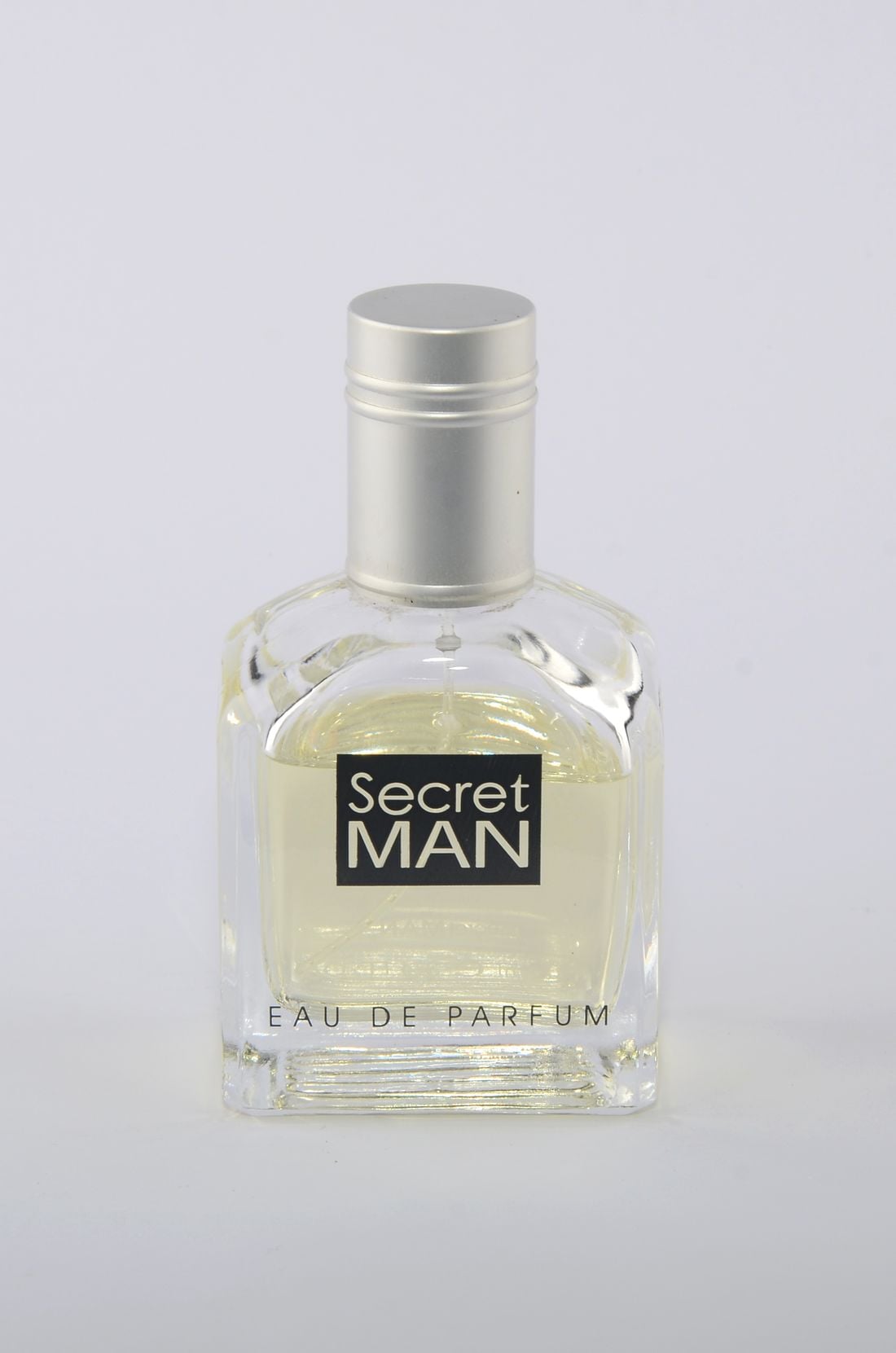 Glass perfume bottle photographed against a neutral studio background