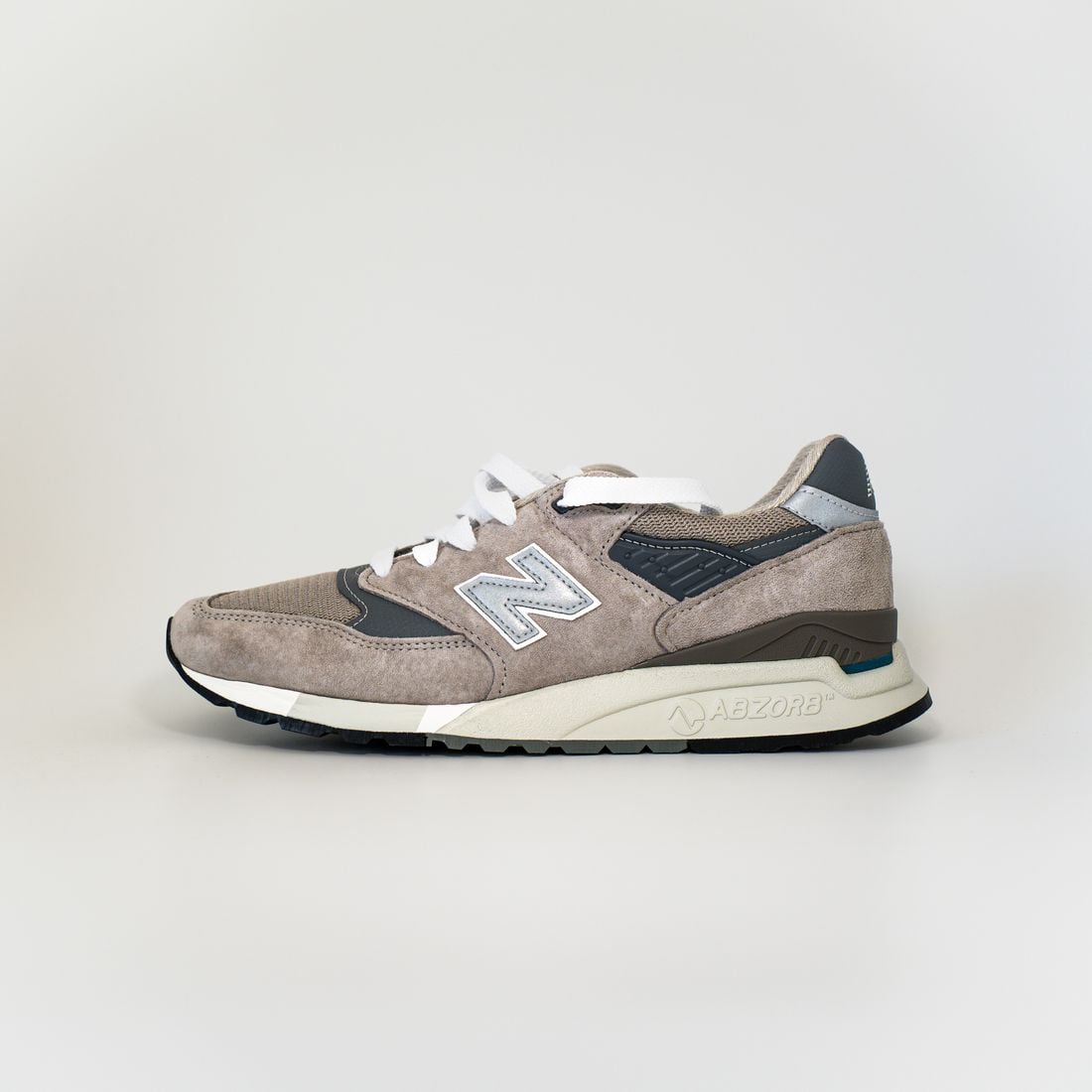 Gray suede sneaker in side profile on a neutral studio background
