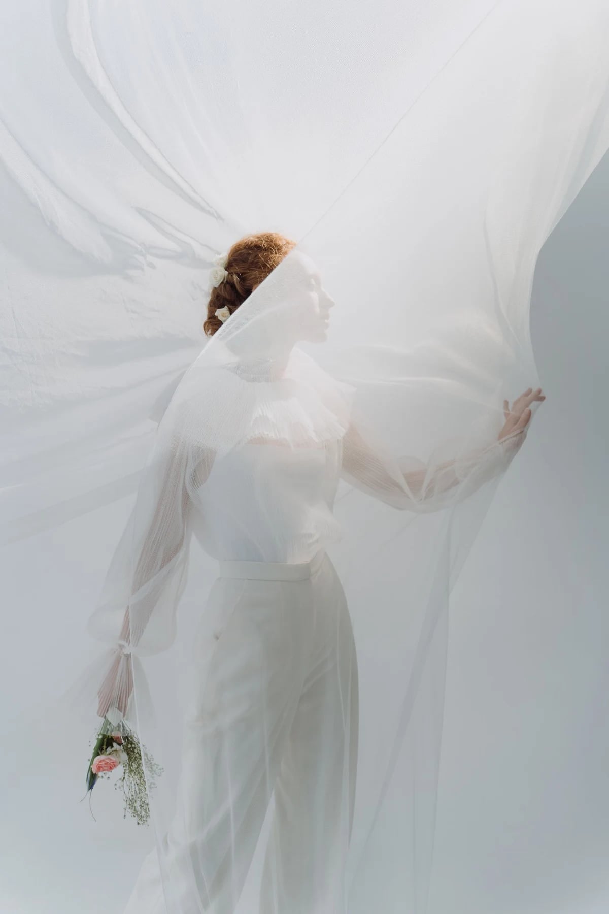 Woman behind flowing sheer white fabric